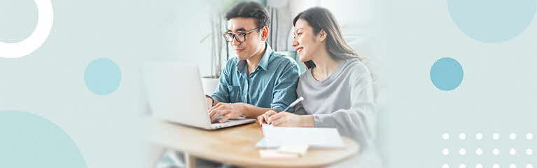 Happy couple looking at laptop