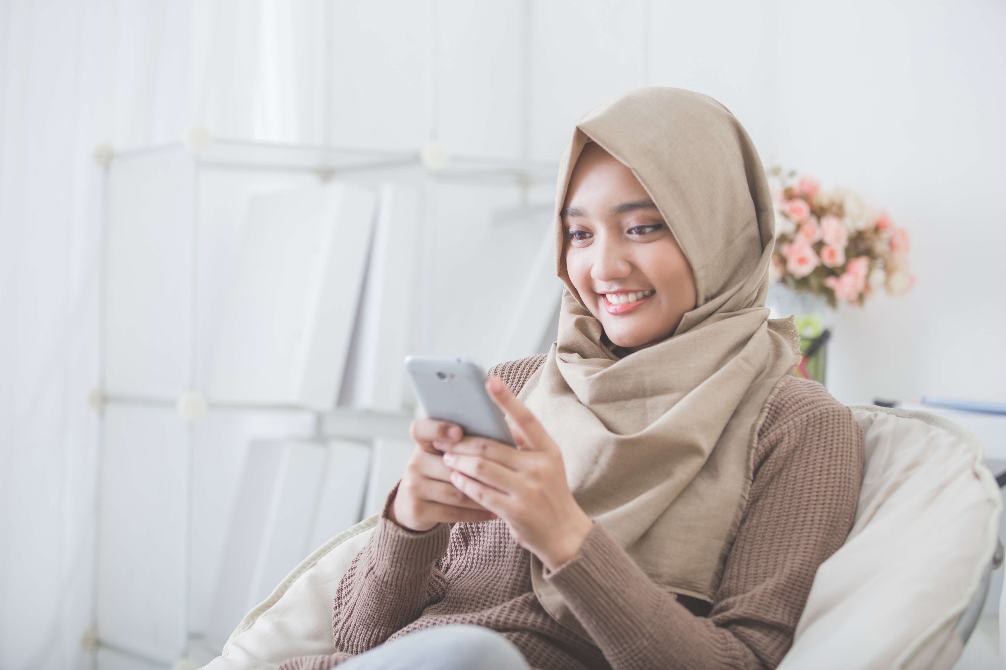 Lady smiling as she looks up information on her phone