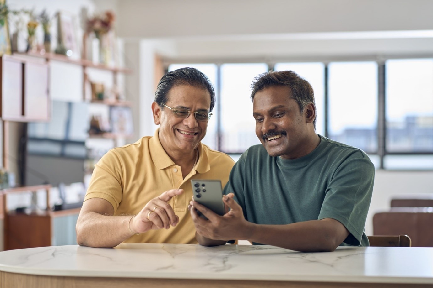 Two men looking happily at their mobile phones
