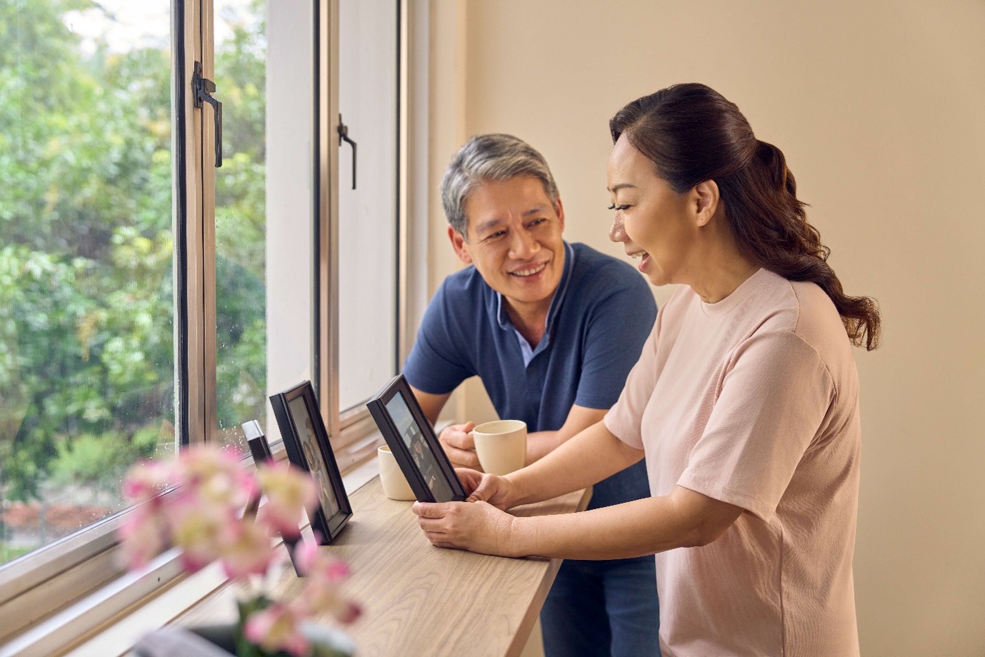 Elderly couple looking at photographs at home