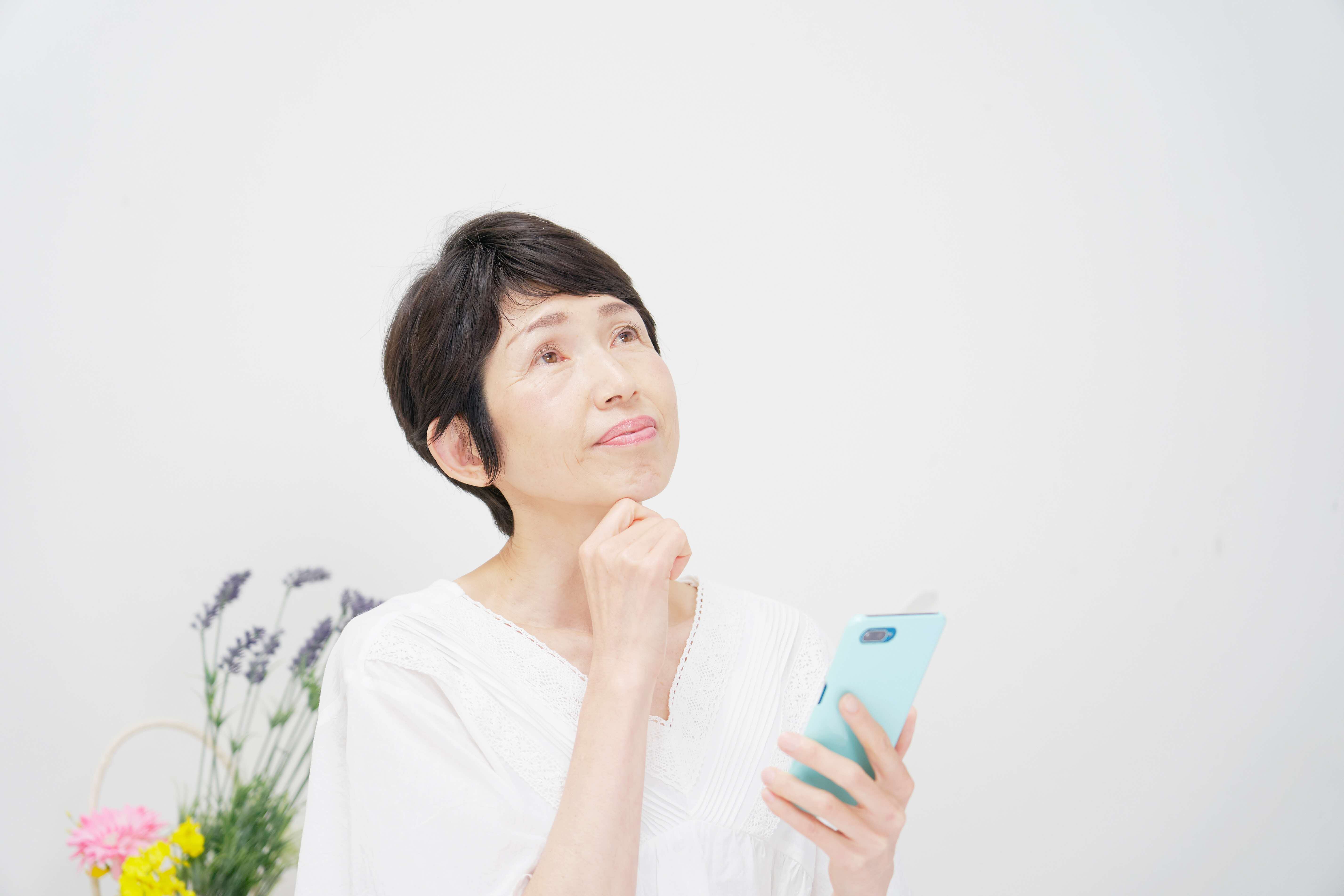 Senior lady thinking as she checks her phone