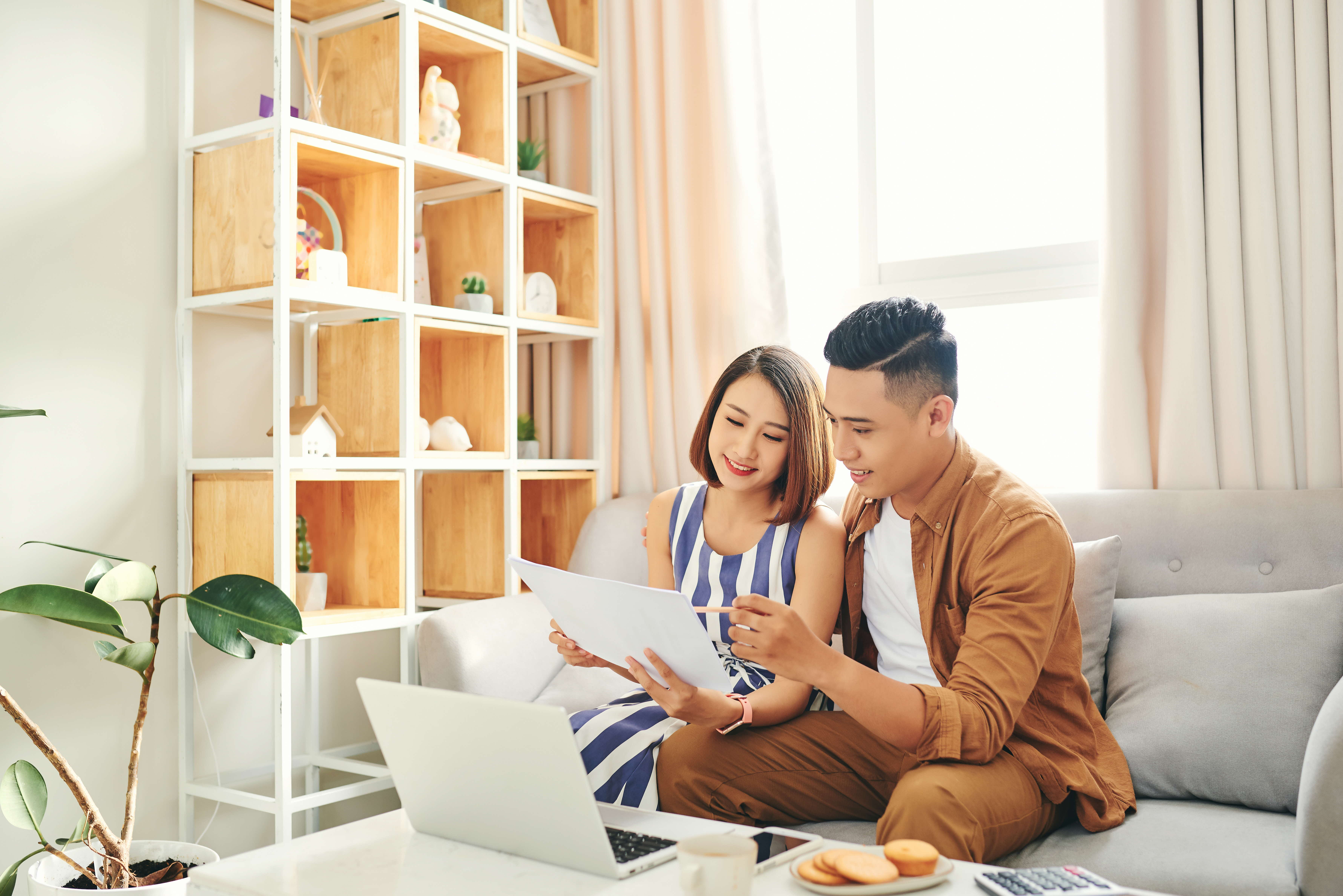Couple planning finances in front of a laptop