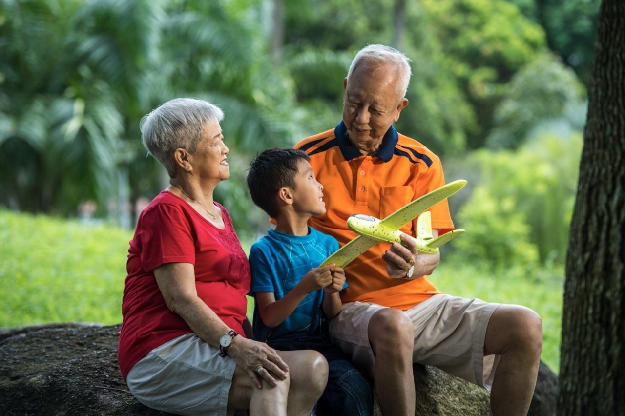 A senior couple playing with their grandson