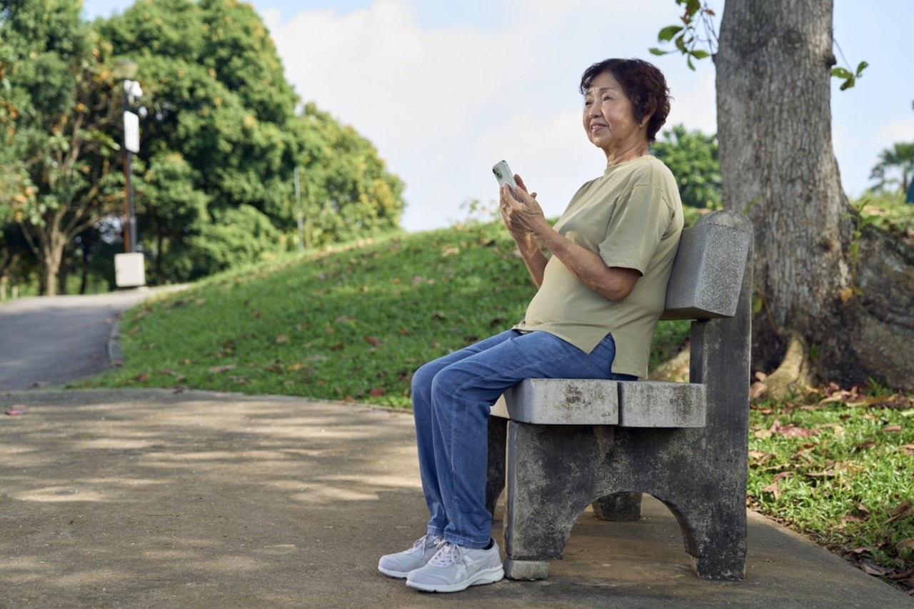 Senior member sitting on a bench in a park