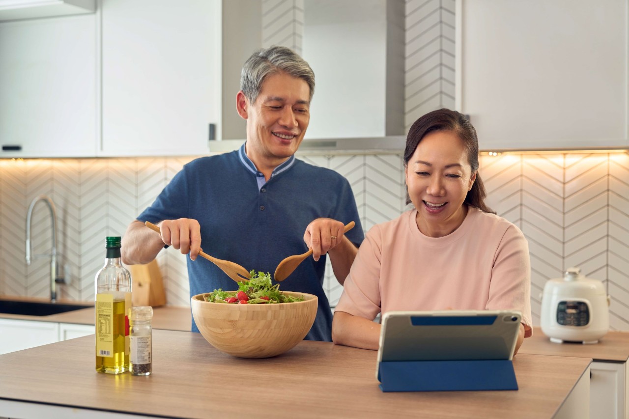 senior couple cooking during video call
