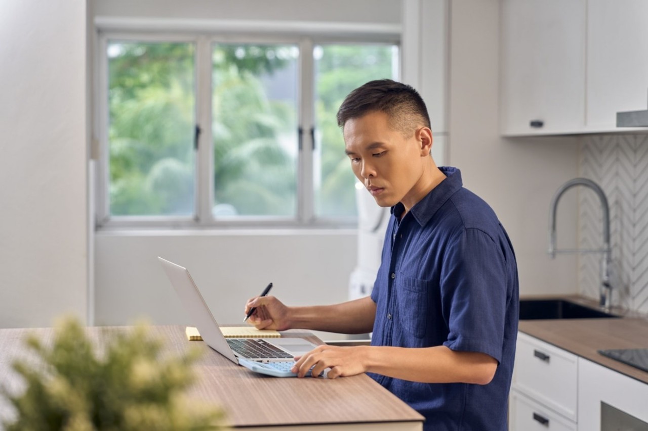 Male adult performing financial planning in his kitchen