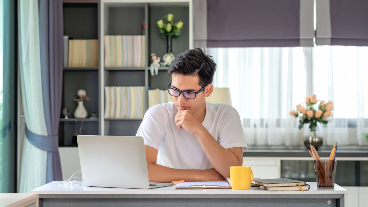 Young man using laptop to plan his finances