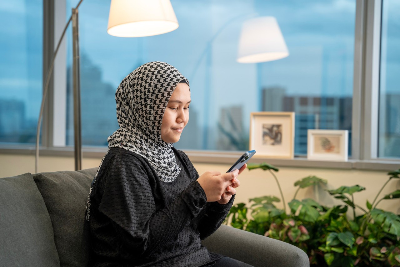 Lady smiling as she looks up information on her phone