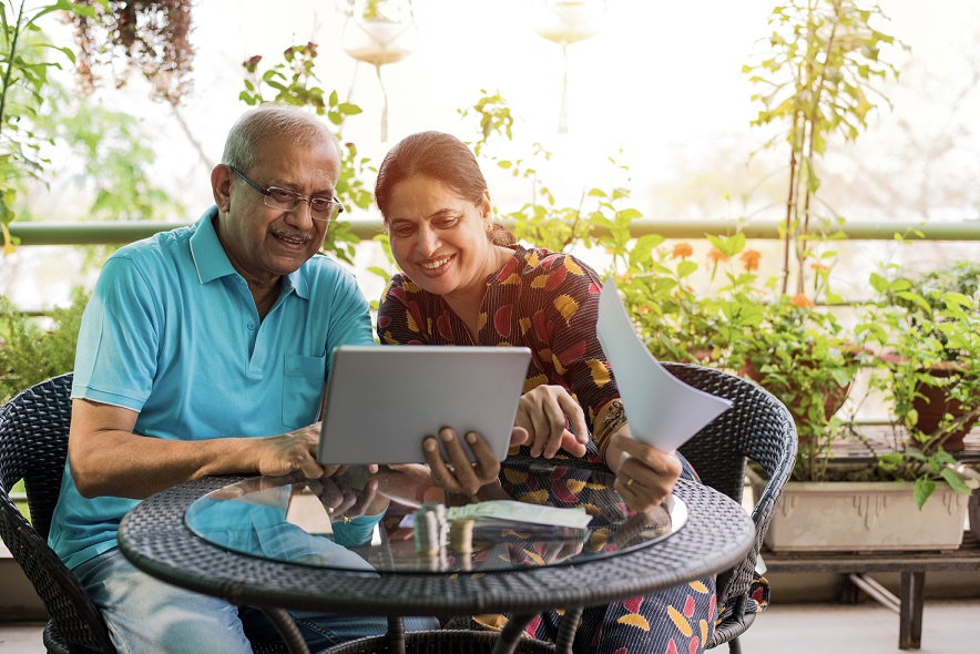 Elderly couple looking at a tablet and smiling