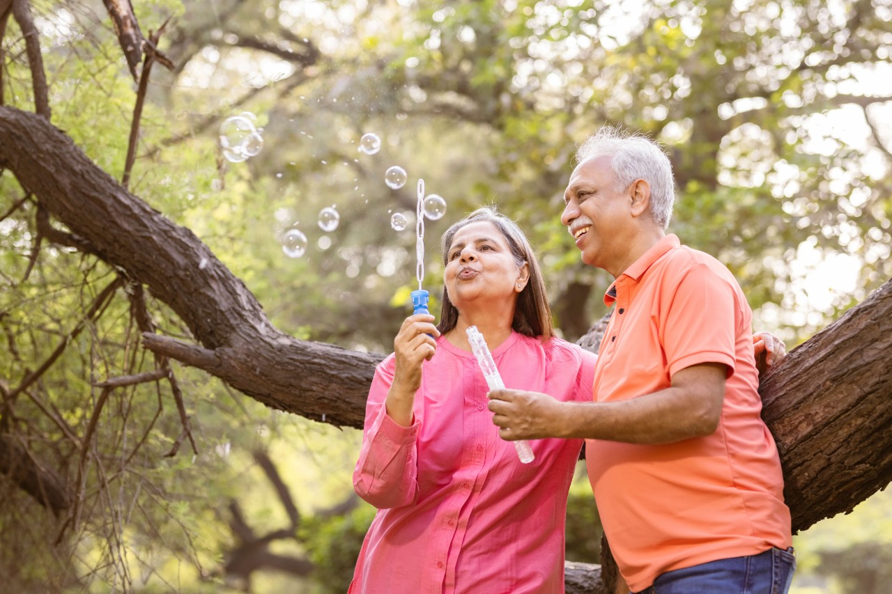 Senior couple blowing bubbles, enjoying retirement