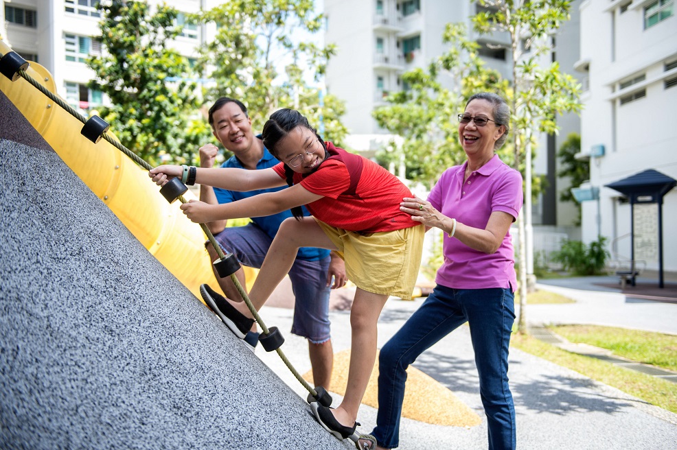 grandparents playing with granddaughter at the playground