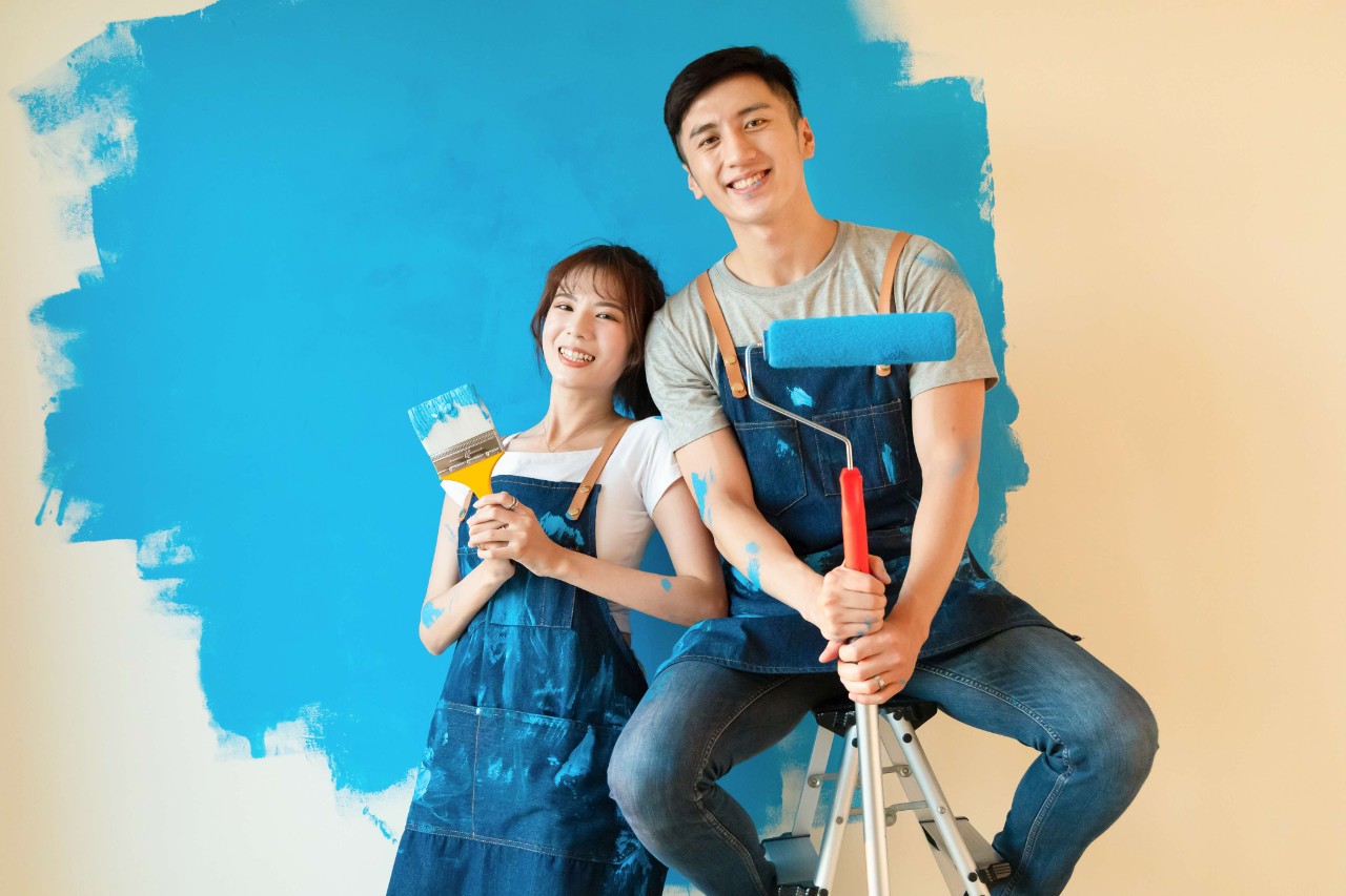 Young couple painting the walls of their new home