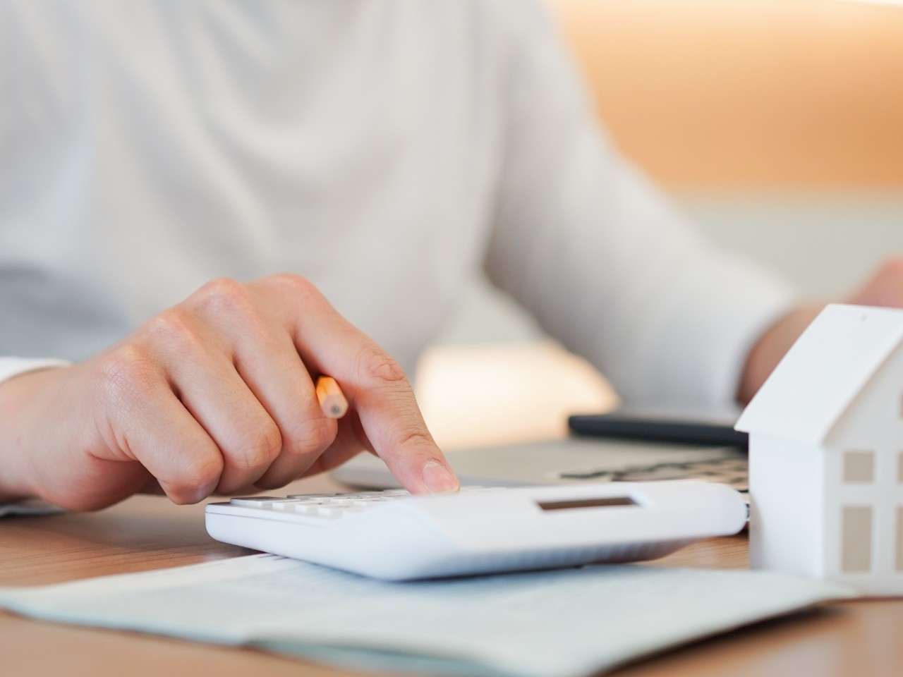 buying and selling a house man calculating the costs with a calculator