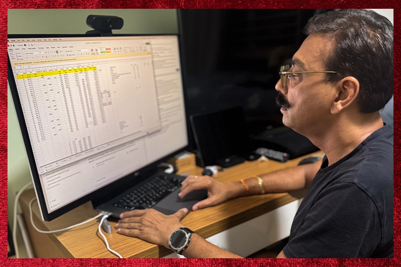 Man looking at a spreadsheet of numbers on a computer