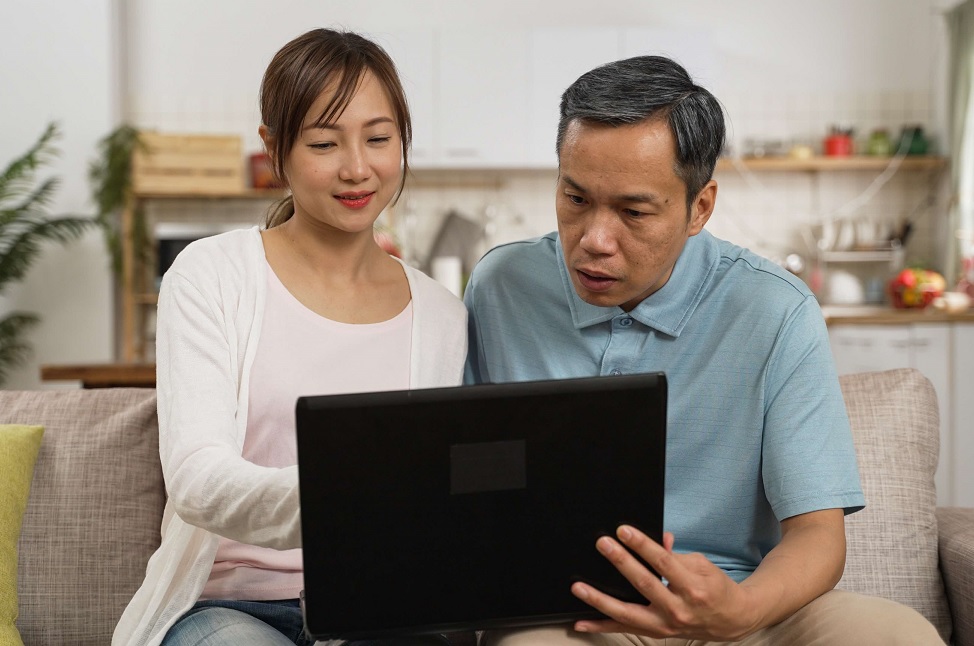 father and daughter looking at a laptop together