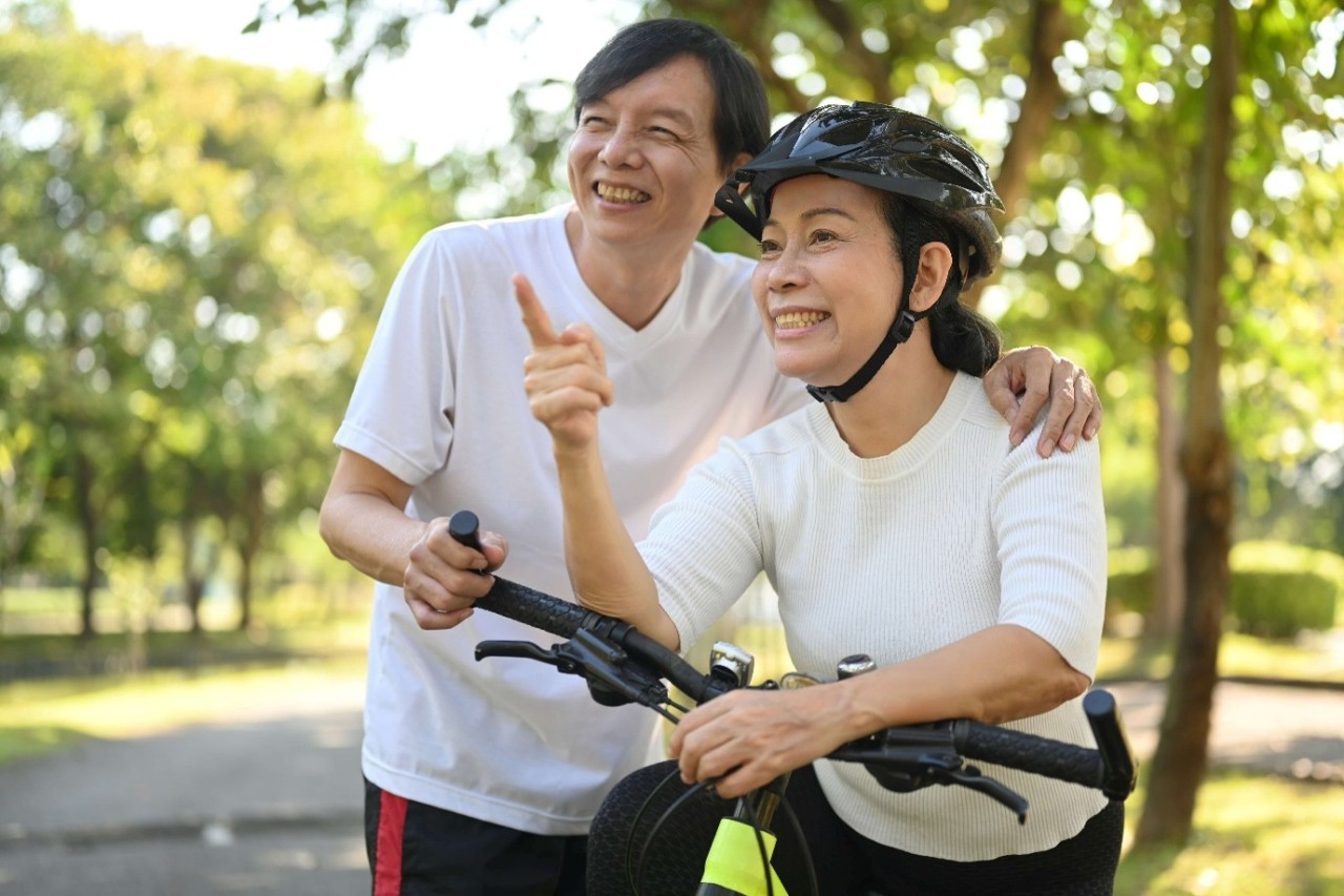 young seniors cycling together in the park