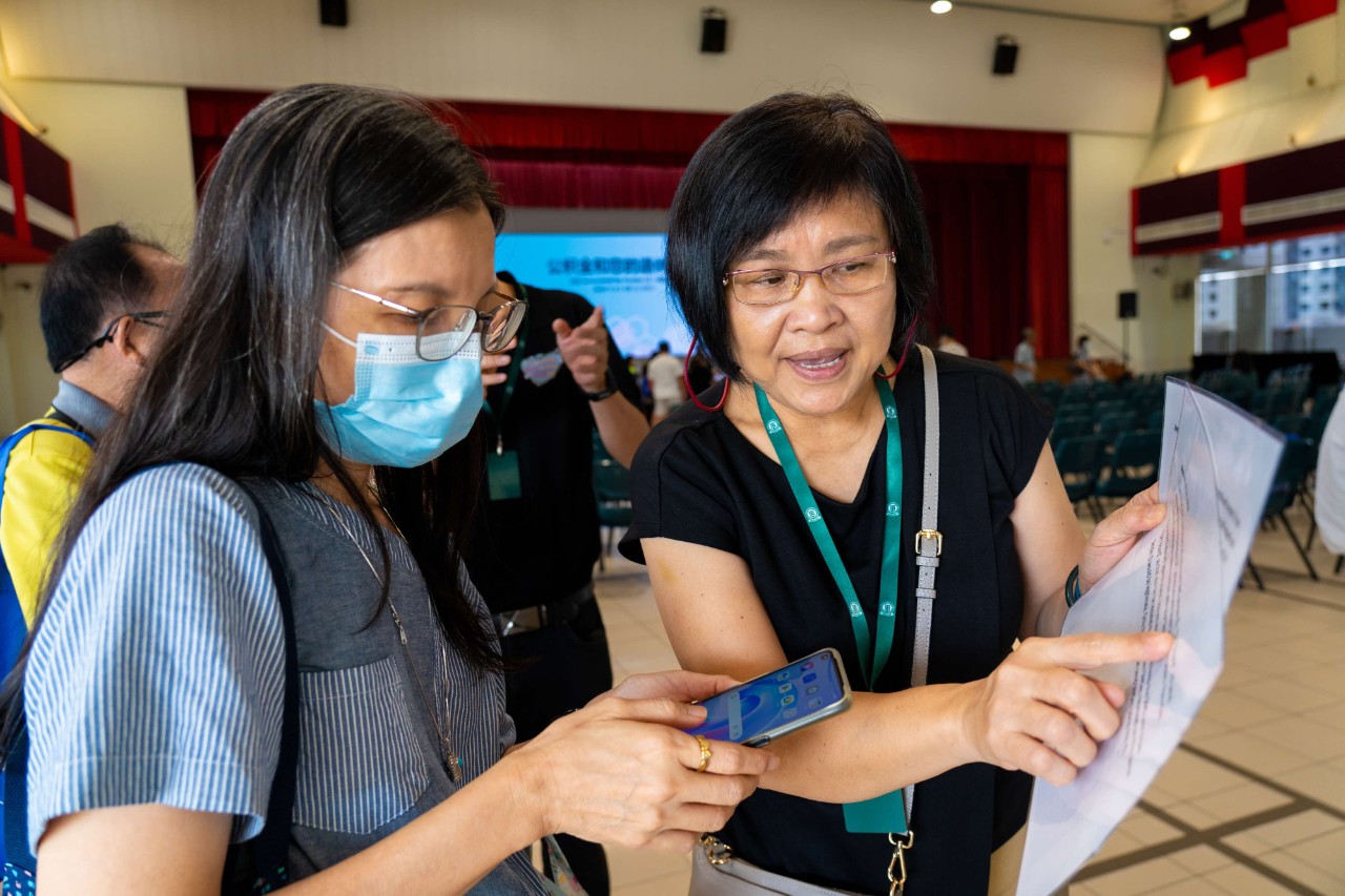 Hwee Boon guiding a member of the public at a CPF roadshow