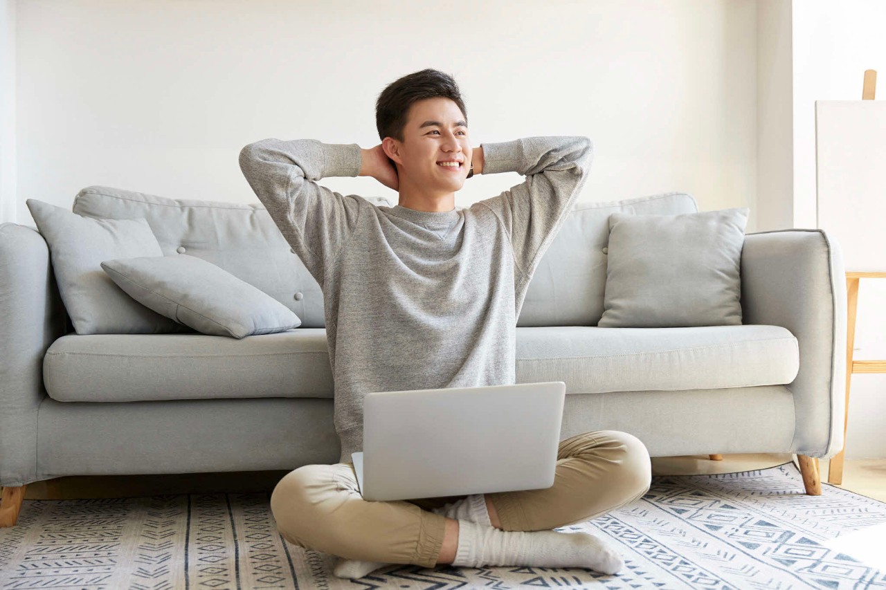 Chinese male relaxing at home with his laptop 