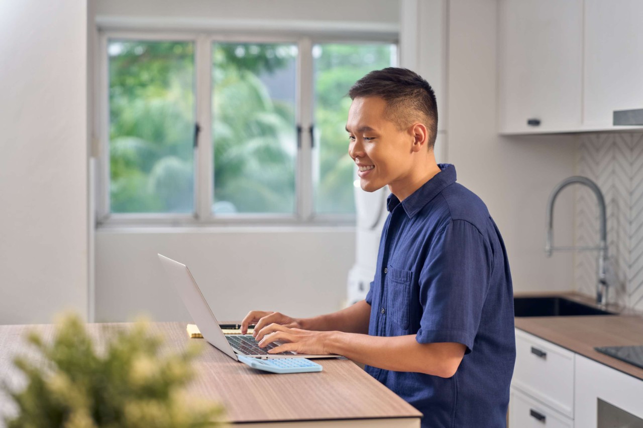 Young adult smiling as he plans his finances