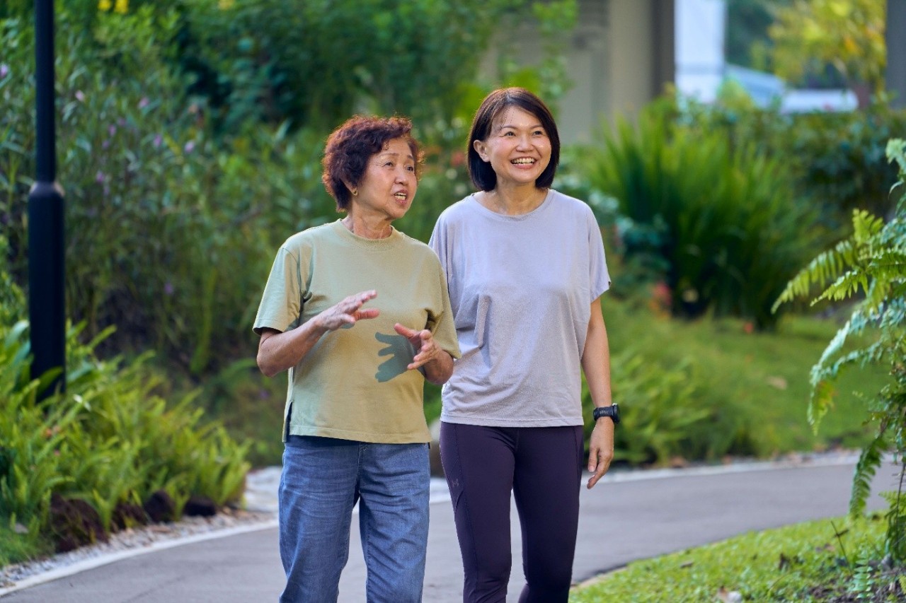 An elderly mother and her daughter walking in the park