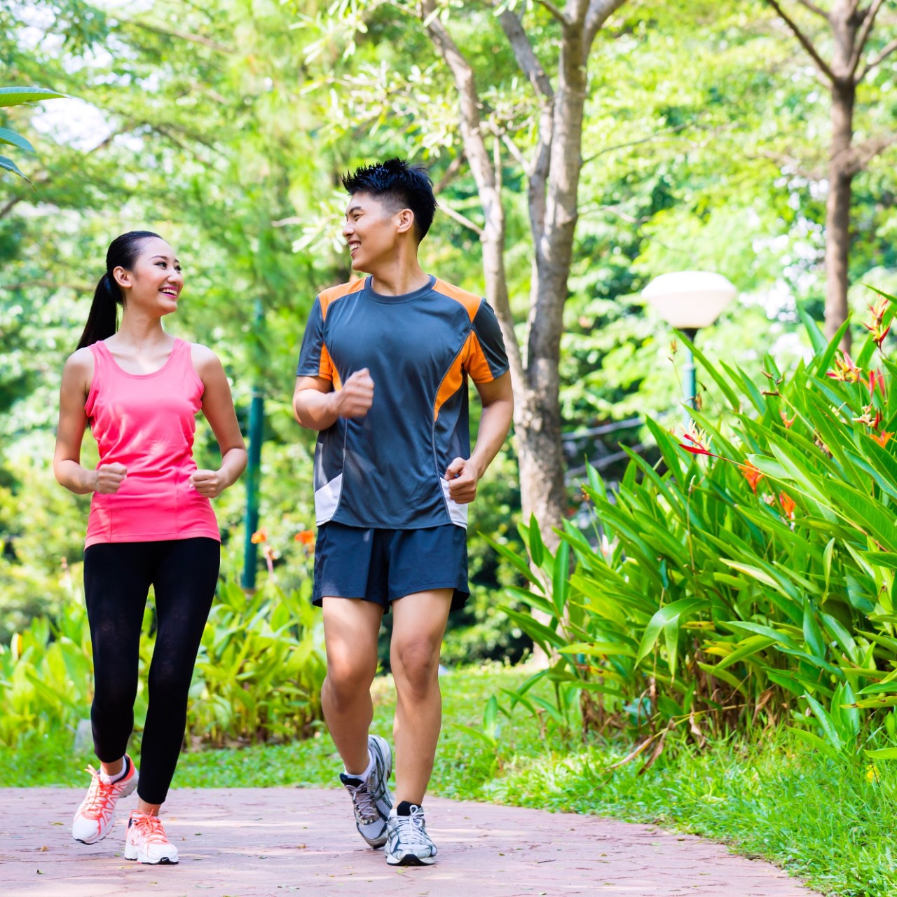 Asian Chinese man and woman jogging in city park